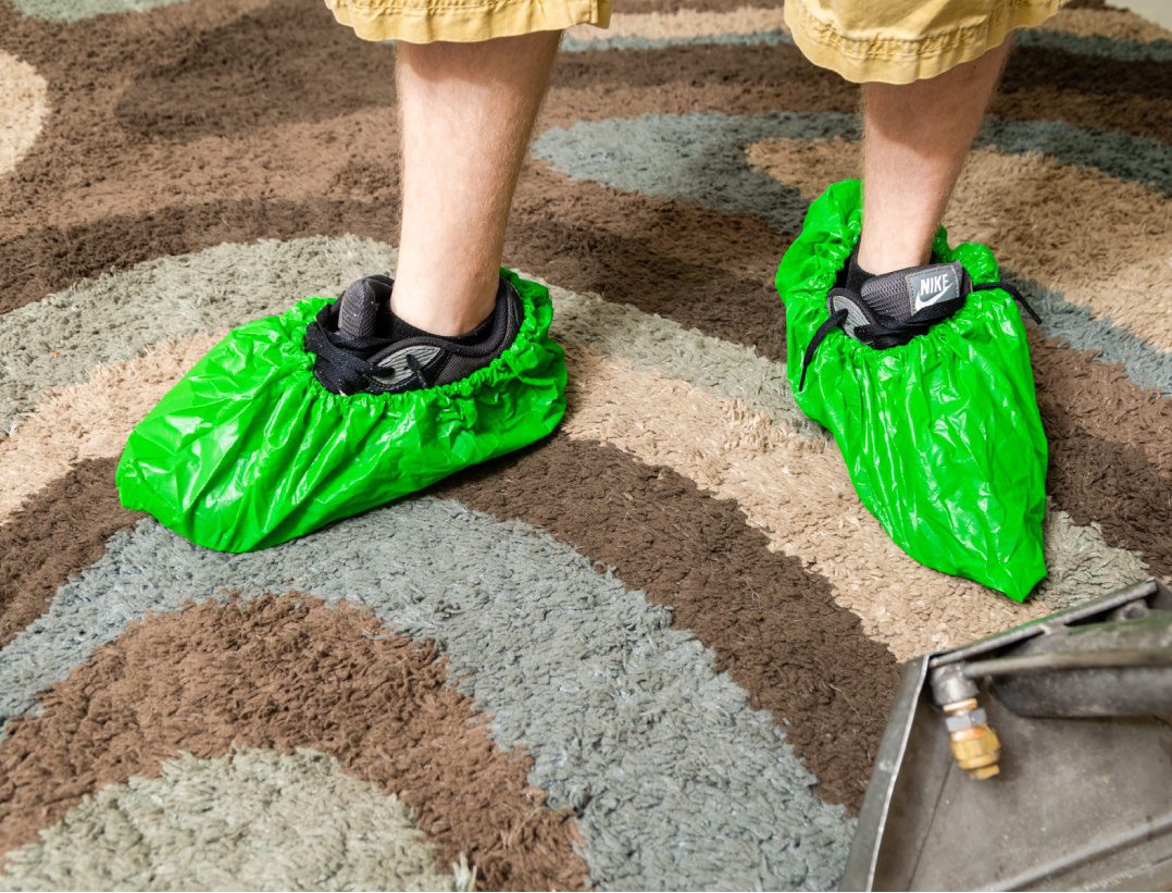 A person wearing green shoes on the ground